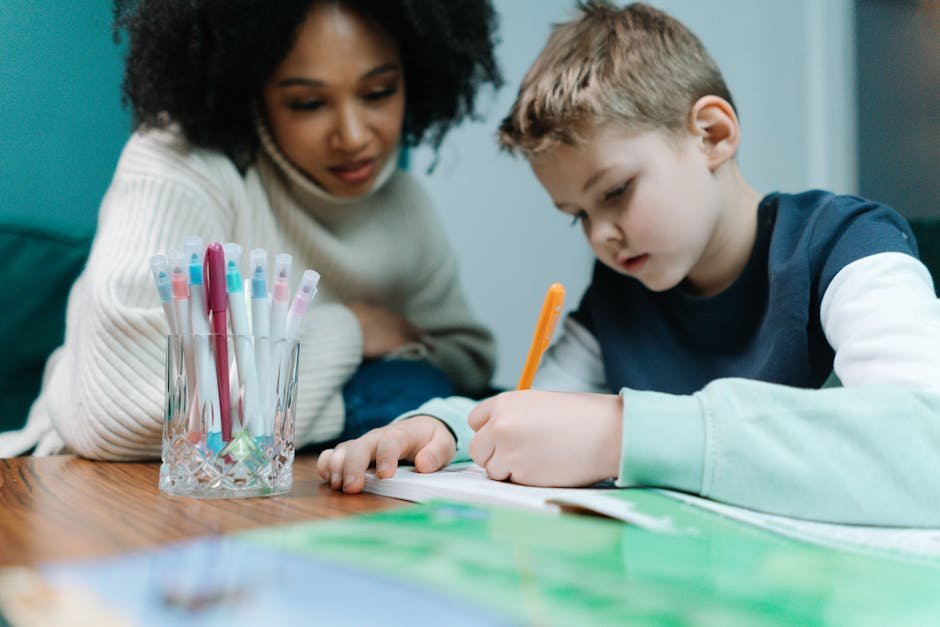 pexels-photo-6986439-6986439-1 A young child writes while being supported by a teacher, focusing on learning.